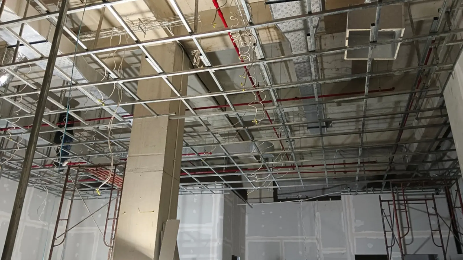 Ceiling exposed during fit out showing ductwork, cable trays, sprinkler pipework and lighting installation.