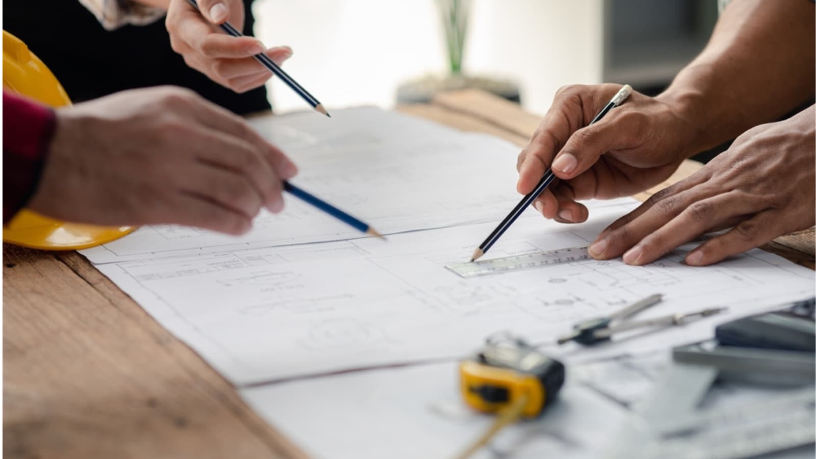 Design workshop with architects, client representatives and project managers reviewing plans and material samples.