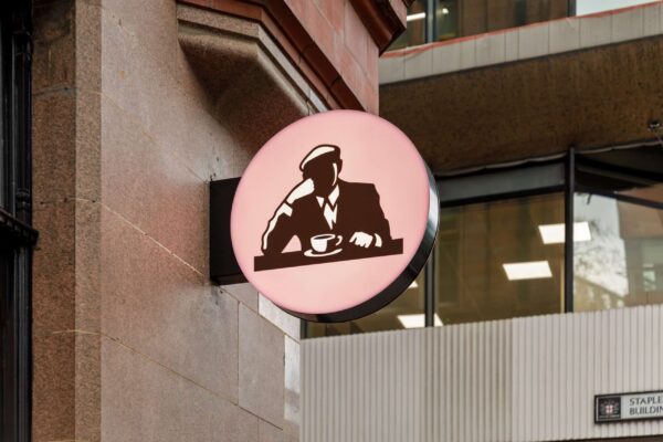 Illuminated circular Joe & The Juice projecting sign mounted on a stone building on High Holborn.