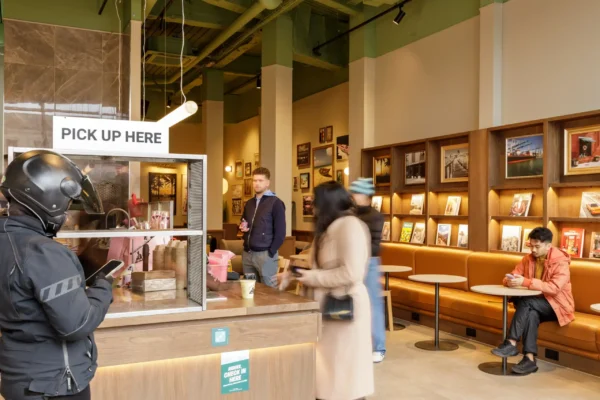 Pick-up station at the Joe & The Juice Wimbledon counter with banquette seating and display shelving behind