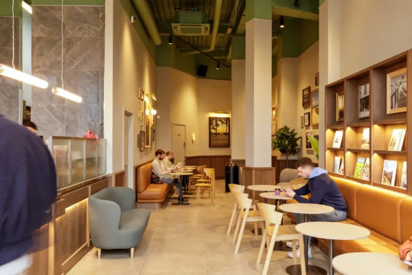 Seating area at Joe & The Juice Wimbledon with lounge chairs, café tables and leather banquette along the back wall