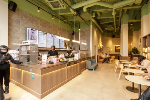 Joe & The Juice Wimbledon counter with digital menu boards, marble-effect wall tiles and pendant lighting